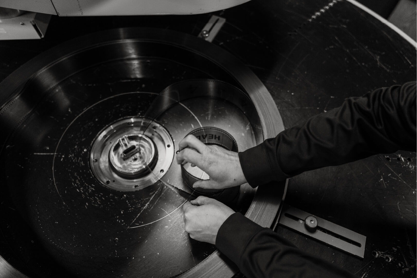 Hands threading IMAX 70MM film onto the platter